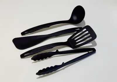 a group of black plastic utensils on a white background at Higashi-Shinjuku 1010 in Tokyo