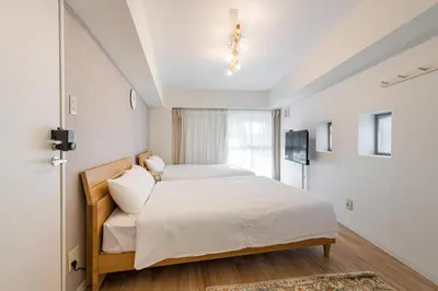 a bedroom with two beds and a window at Higashi-Shinjuku 1012 in Tokyo