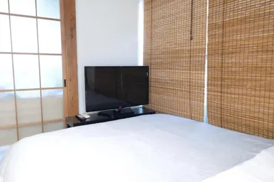 a bedroom with a bed and a flat screen tv at Yoyogi Flats - Vacation STAY 18018 in Tokyo