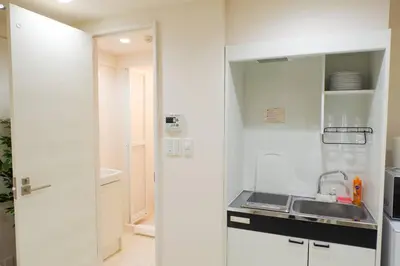 a small white kitchen with a sink and a counter at SLEEPLAB THE STAY Casual \u65b0\u5bbf2 in Tokyo
