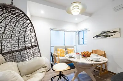 a living room with a table and a chair at K's Casa西新井 駅徒歩4分 ディズニー車26分 56m2 ハンギングチェア 下町の快い暮らし in Tokyo