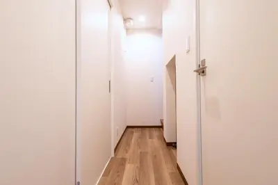a hallway with white walls and a wooden floor at K's Casa西新井 駅徒歩4分 ディズニー車26分 56m2 ハンギングチェア 下町の快い暮らし in Tokyo