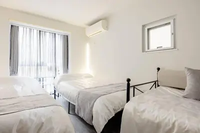a bedroom with two beds and a window at \u30a2\u30f3\u30c9\u30b9\u30c6\u30a4\u767d\u91d16\u4e01\u76ee301 in Tokyo