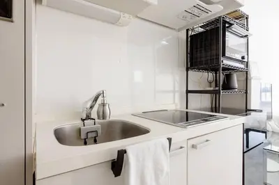 a white kitchen with a sink and a stove at \u30a2\u30f3\u30c9\u30b9\u30c6\u30a4\u767d\u91d16\u4e01\u76ee301 in Tokyo