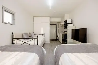 a hotel room with two beds and a flat screen tv at \u30a2\u30f3\u30c9\u30b9\u30c6\u30a4\u767d\u91d16\u4e01\u76ee301 in Tokyo