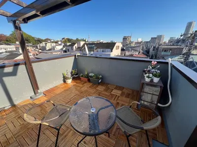 a patio with a table and chairs on a balcony at HOTEL Kyo in Tokyo