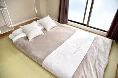 a large bed in a room with a window at HOTEL Kyo in Tokyo