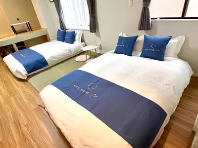 two beds in a room with blue and white at HOTEL Kyo in Tokyo