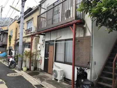 a motorcycle parked next to a building with a balcony at Shibuya South JP House in Tokyo