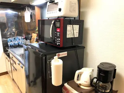 a microwave on top of a refrigerator in a kitchen at Shibuya South JP House in Tokyo