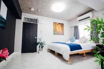 a bedroom with a large bed with a blue blanket at \u685c\u306e\u5ddd16 \u6c60\u888b\u4e00\u6238\u5efa \u6c60\u888b\u99c5 5\u5206 2-11\u4eba\u4e28Ikebukuro Villa Ikebukuro 5 minutes 2-11 people in Tokyo