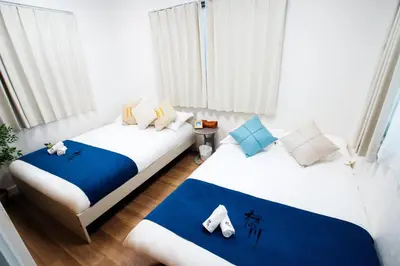 two beds in a room with white and blue at \u685c\u306e\u5ddd16 \u6c60\u888b\u4e00\u6238\u5efa \u6c60\u888b\u99c5 5\u5206 2-11\u4eba\u4e28Ikebukuro Villa Ikebukuro 5 minutes 2-11 people in Tokyo