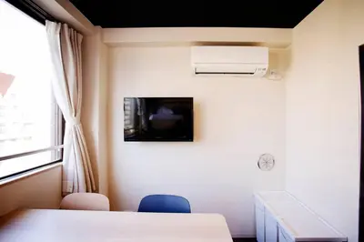 a room with a table and a tv on a wall at Harebare apartment for max 4ppl 3mins walk from Kiba station 5F in Tokyo