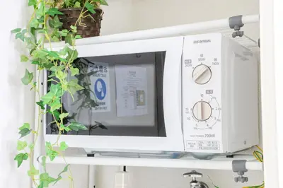 a microwave oven on a shelf with a plant at \u30cf\u30a4\u30af\u30ec\u30b9\u30c8\u4e2d\u91ce202 in Tokyo