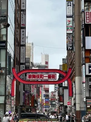 a city street with a red sign hanging between buildings at \u30cf\u30a4\u30af\u30ec\u30b9\u30c8\u4e2d\u91ce102 in Tokyo