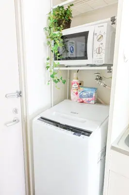 a small kitchen with a white washer and dryer at \u30cf\u30a4\u30af\u30ec\u30b9\u30c8\u4e2d\u91ce102 in Tokyo