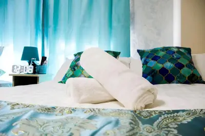a bed with a pile of towels on it at #3 -\u30a8\u30af\u30bb\u30eb\u6a4b\u7acb101- Entire Unit in Tokyo