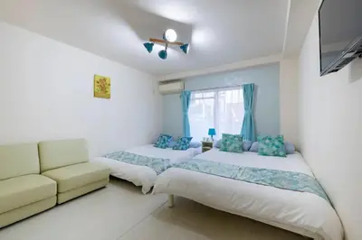 a bedroom with two beds and a couch at #3 -\u30a8\u30af\u30bb\u30eb\u6a4b\u7acb101- Entire Unit in Tokyo