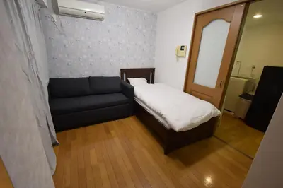 a small room with a bed and a couch at \u6587\u4eac\u533a\u8c4a\u5cf6\u533a\u5357\u5927\u585a in Tokyo
