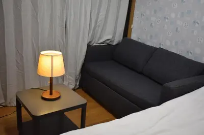 a living room with a couch and a table with a lamp at \u6587\u4eac\u533a\u8c4a\u5cf6\u533a\u5357\u5927\u585a in Tokyo