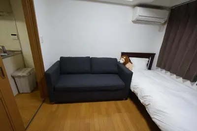 a blue couch sitting on a bed in a room at \u6587\u4eac\u533a\u8c4a\u5cf6\u533a\u5357\u5927\u585a in Tokyo