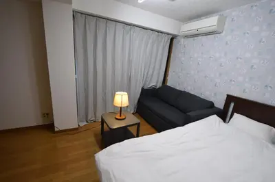 a bedroom with a bed and a couch and a lamp at \u6587\u4eac\u533a\u8c4a\u5cf6\u533a\u5357\u5927\u585a in Tokyo