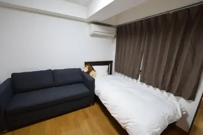 a bed and a couch in a room at \u6587\u4eac\u533a\u8c4a\u5cf6\u533a\u5357\u5927\u585a1 in Tokyo