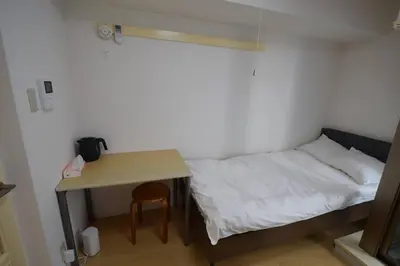 a small room with a bed and a table at \u6771\u4eac\u30e1\u30c8\u30ed\u4e38\u30ce\u5185\u7dda\u5f92\u6b691\u5206 in Tokyo