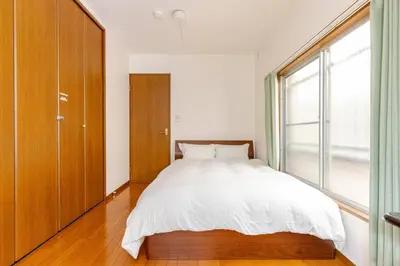 a bedroom with a bed and a large window at kensui house in Tokyo