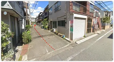 an empty street with a red line on the sidewalk at kensui house in Tokyo