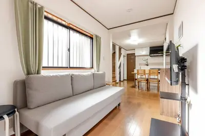 a living room with a couch and a kitchen at kensui house in Tokyo