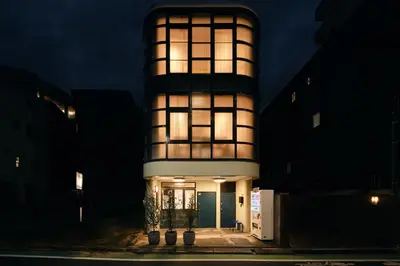 a tall building with lights on it at night at Kaikai House - Art, Design & Family in Shibuya in Tokyo