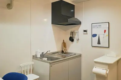 a small kitchen with a sink and a stove at Kaikai House - Art, Design & Family in Shibuya in Tokyo