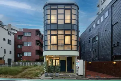 a cylindrical building with windows on the side at Kaikai House - Art, Design & Family in Shibuya in Tokyo