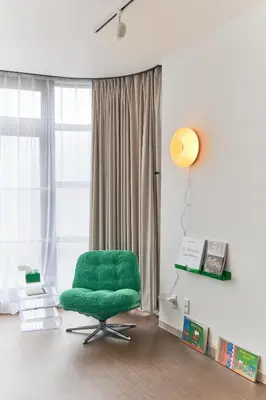 a green chair in a room with a window at Kaikai House - Art, Design & Family in Shibuya in Tokyo