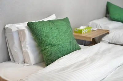 a green pillow sitting on top of a bed at ZJ201 Hanama201 The Skytree Residence A Newly Home by Tokyo Iconic Landmarks in Tokyo
