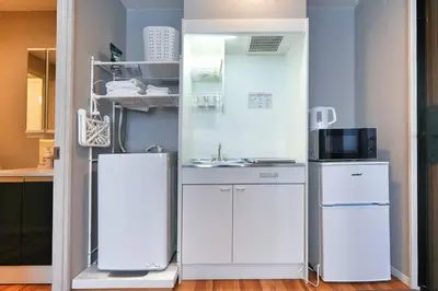 a kitchen with white cabinets and a sink and a refrigerator at ZJ202 Hanama202 The Skytree Residence A Newly Home by Tokyo Iconic Landmarks in Tokyo