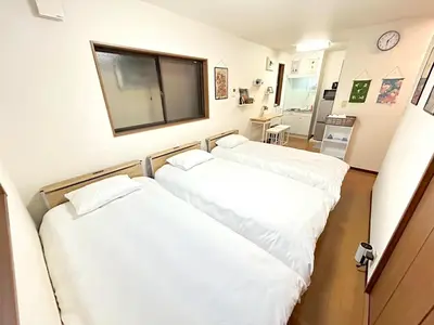 two beds in a room with white sheets at japanese art kiyo-e house traditional towns self check in in Tokyo