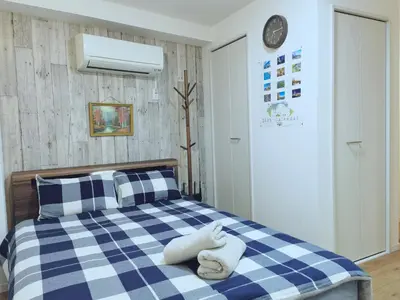 a bedroom with a blue and white checkered bed at #301WZNET\u6885\u5c4b\u6577\u99c52\u5206\u6a2a\u6d5c\u7fbd\u7530\u7a7a\u6e2f\u90fd\u5fc3\u4fbf\u5229\u5546\u5e97\u88571k\u9759\u304b\u306a\u753a in Tokyo