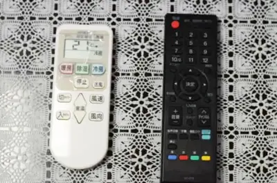 two remote controls sitting next to each other on a table at #5 -\u30a8\u30af\u30bb\u30eb\u6a4b\u7acb103- Entire Unit in Tokyo