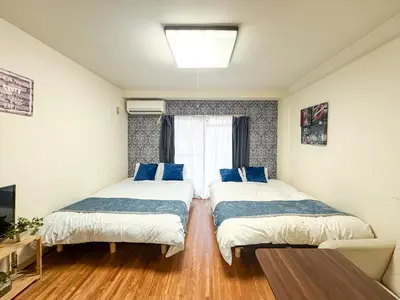 a bedroom with two beds with blue pillows at #5 -\u30a8\u30af\u30bb\u30eb\u6a4b\u7acb103- Entire Unit in Tokyo