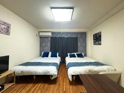 a room with two beds and a television in it at #5 -\u30a8\u30af\u30bb\u30eb\u6a4b\u7acb103- Entire Unit in Tokyo