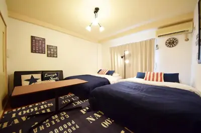 a bedroom with two beds with blue comforters at #6 -\u30a8\u30af\u30bb\u30eb\u6a4b\u7acb203- Entire Unit in Tokyo