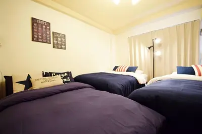 three beds in a room with blue sheets at #6 -\u30a8\u30af\u30bb\u30eb\u6a4b\u7acb203- Entire Unit in Tokyo