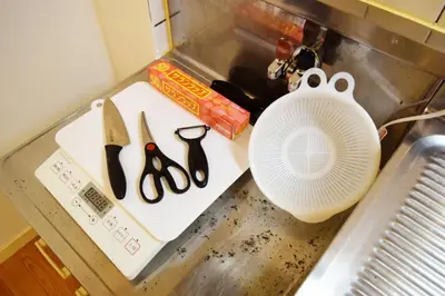 a counter with a cutting board with scissors and a container at #6 -\u30a8\u30af\u30bb\u30eb\u6a4b\u7acb203- Entire Unit in Tokyo
