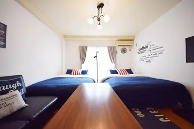a bedroom with two beds and a couch at #6 -\u30a8\u30af\u30bb\u30eb\u6a4b\u7acb203- Entire Unit in Tokyo