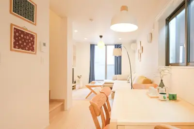 a dining room and living room with a table and chairs at Mi-Villa SOMO in Tokyo