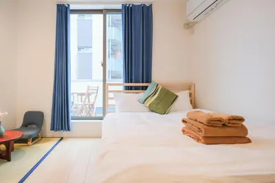 a bedroom with a bed with towels on it at Mi-Villa SOMO in Tokyo
