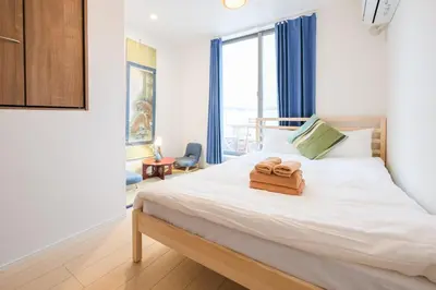 a bedroom with a bed with two towels on it at Mi-Villa SOMO in Tokyo