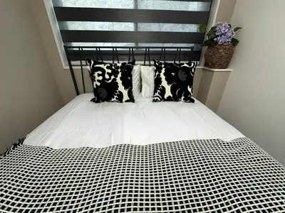 a bed with black and white sheets and pillows at COMMA HOUSE Shinjuku 11 in Tokyo